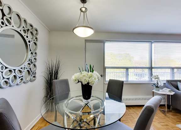 a dining room with a glass table and chairs