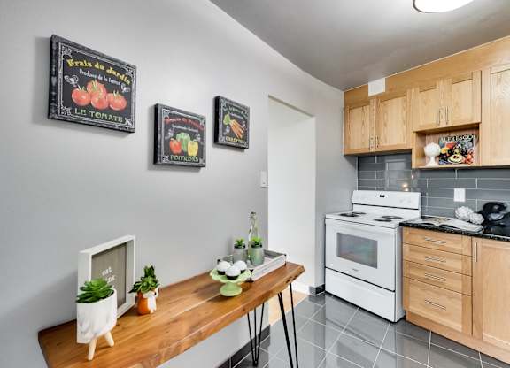 a kitchen with white appliances and a wooden table