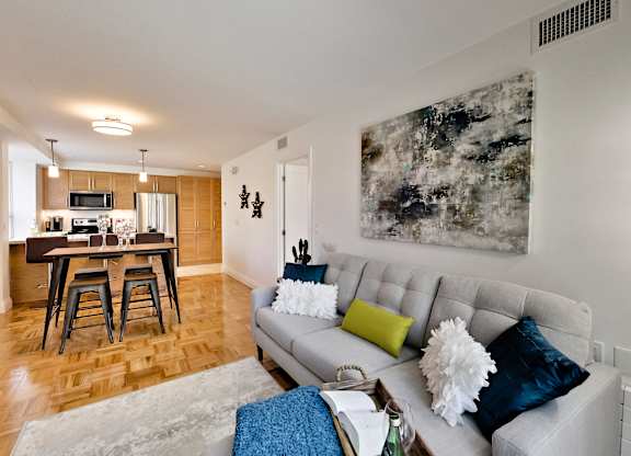a living room with a couch and a kitchen with a bar