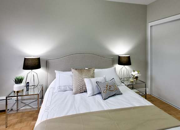a bedroom with a bed with white sheets and pillows