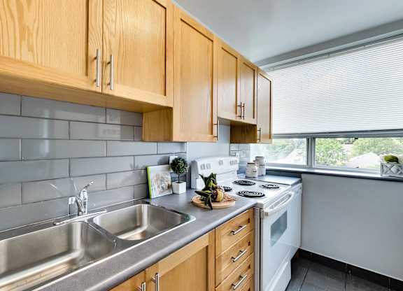 a kitchen with wood cabinets and white appliances and a sink