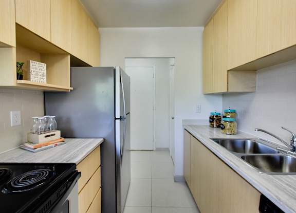 a kitchen with wooden cabinets and a stainless steel refrigerator