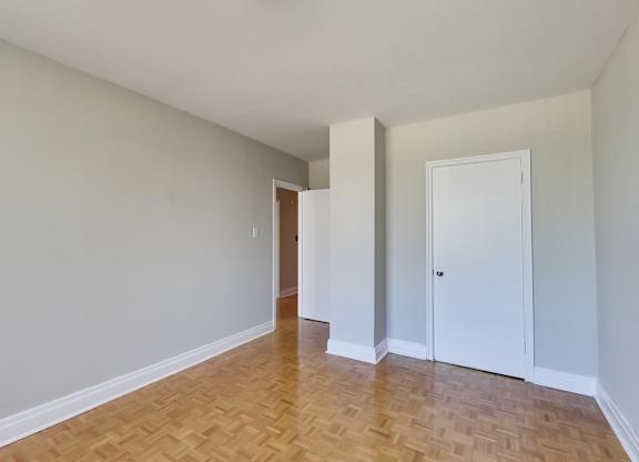 an empty living room with wood flooring and white walls