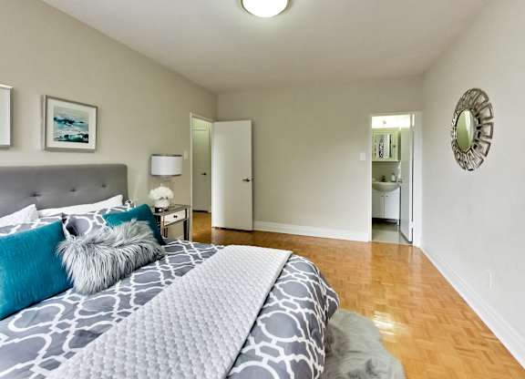 a bedroom with a large bed and a bathroom in the background