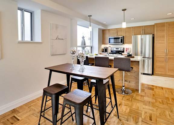 a kitchen and dining room with a wooden table and chairs