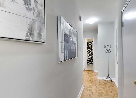 a hallway with pictures on the wall and a door to a closet