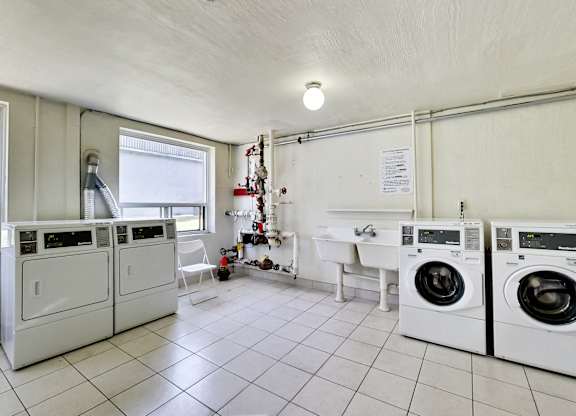 a laundry room with washing machines and a sink