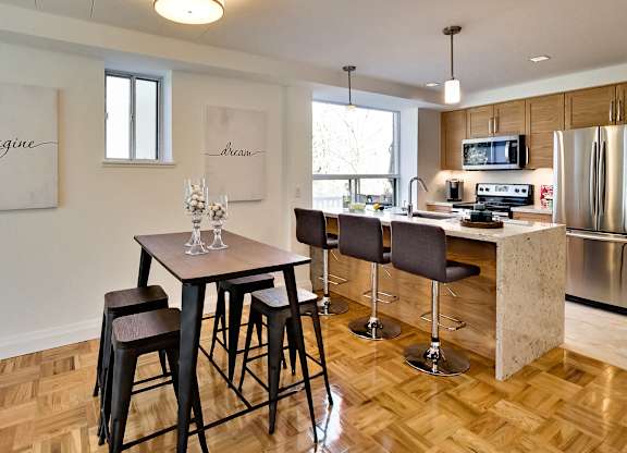 a kitchen and dining room with a wooden floor and a table with chairs
