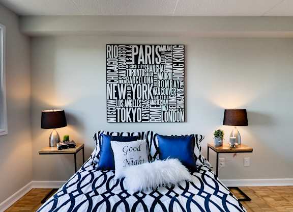 a bedroom with a bed with blue and white pillows and a sign above it