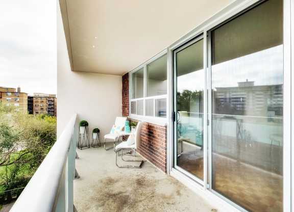 A balcony with a person sitting on a chair.
