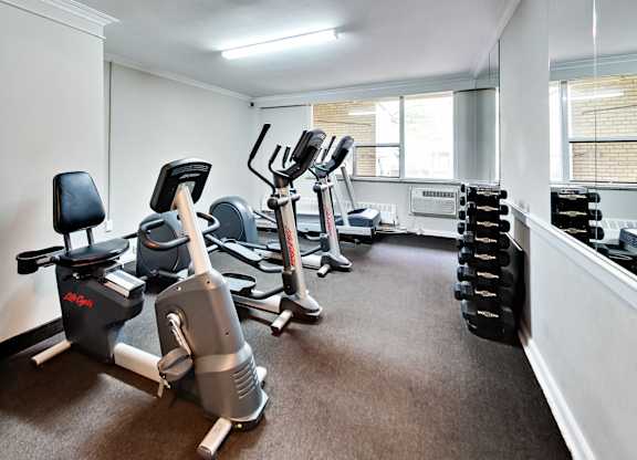 a gym with cardio machines and weights on the floor