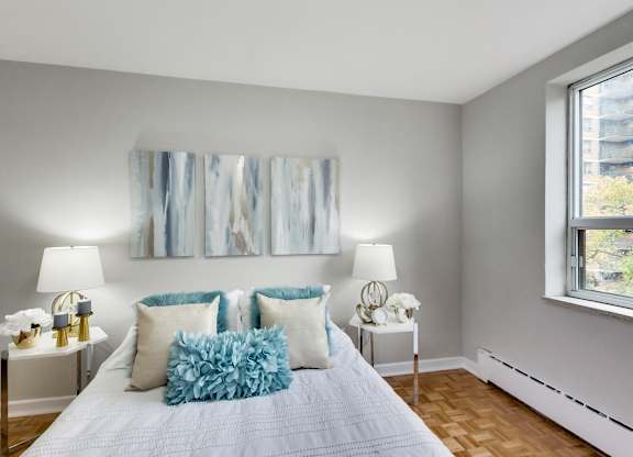 a bedroom with a bed with pillows and artwork on the wall