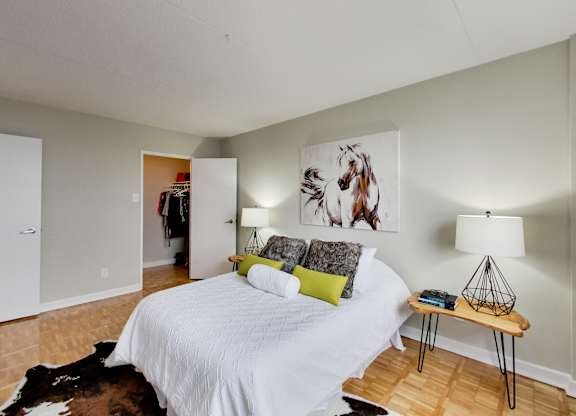 a bedroom with a white bed and a painting on the wall
