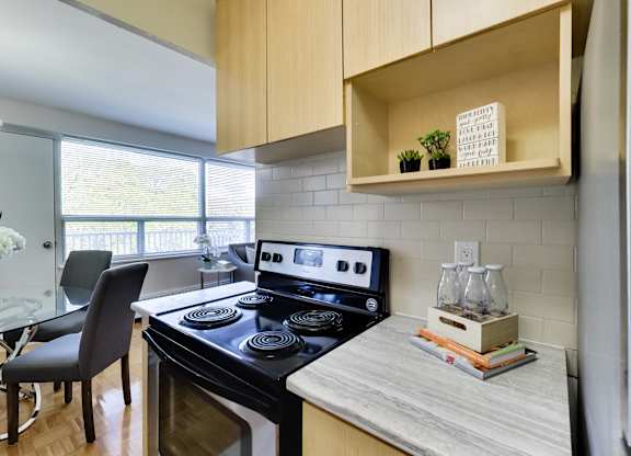 a kitchen with a stove and a sink and a window