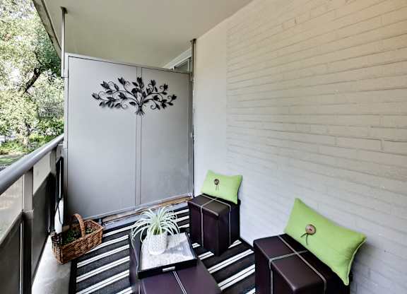 A small balcony with a white wall and a plant on a tray.