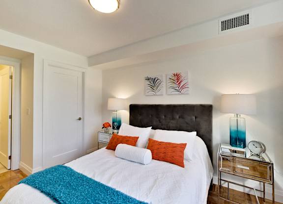 a bedroom with a white bed and a black headboard
