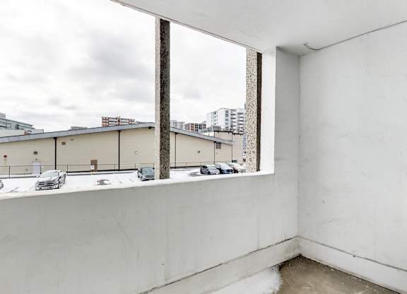 an empty room with a large window overlooking a parking lot