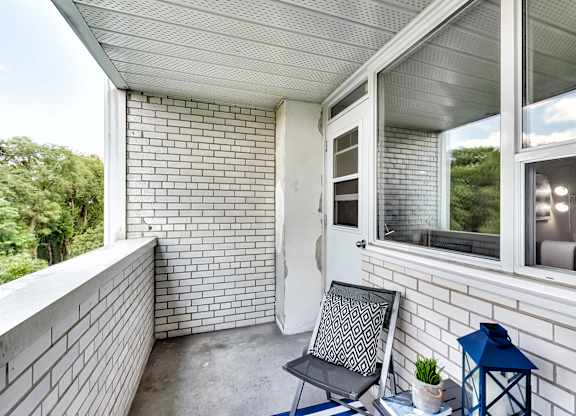 a balcony with a chair and a table and a window