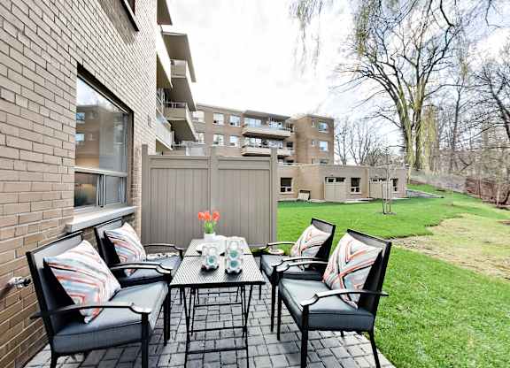 a backyard patio with a table and chairs and a garden
