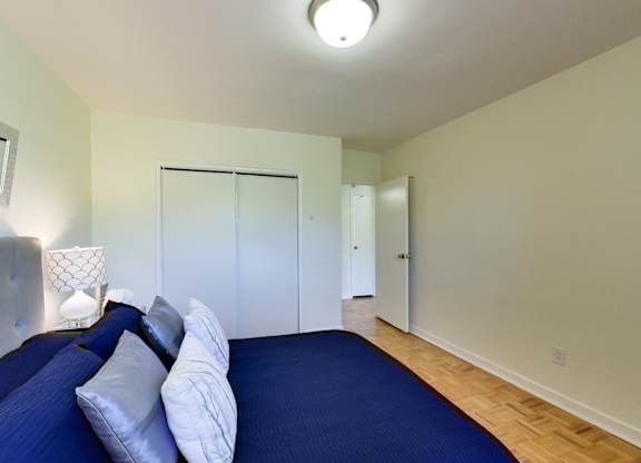 a bedroom with a large blue bed and a closet