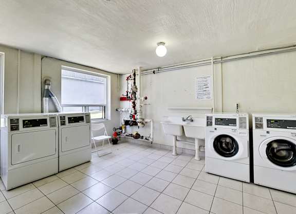 a laundry room with washing machines and a sink