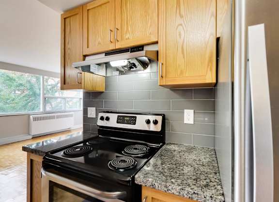 a kitchen with wood cabinets and black appliances and granite counter tops