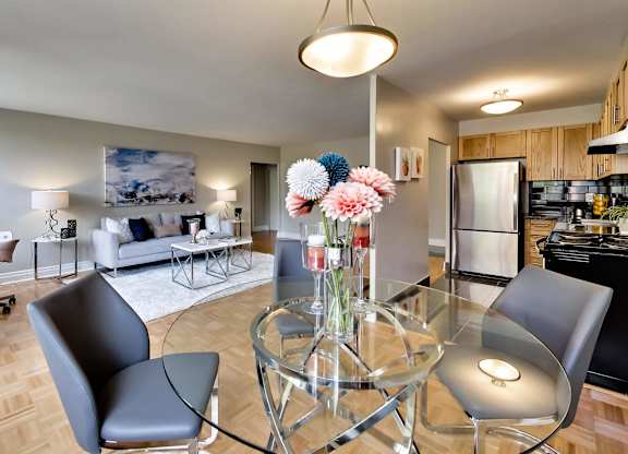 a living room with a glass table with a vase of flowers