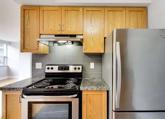 a kitchen with stainless steel appliances and wooden cabinets