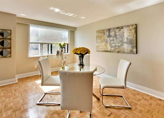 a dining room with a table and chairs and a window