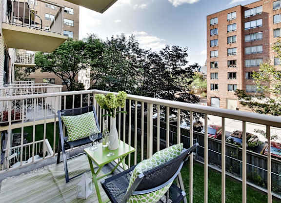 a balcony with two chairs and a table