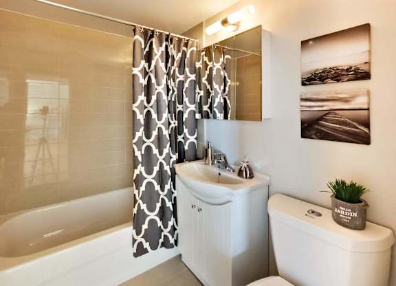 a bathroom with a shower curtain and a toilet and a sink