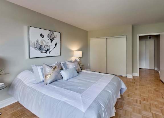 a bedroom with a white bed and a painting on the wall