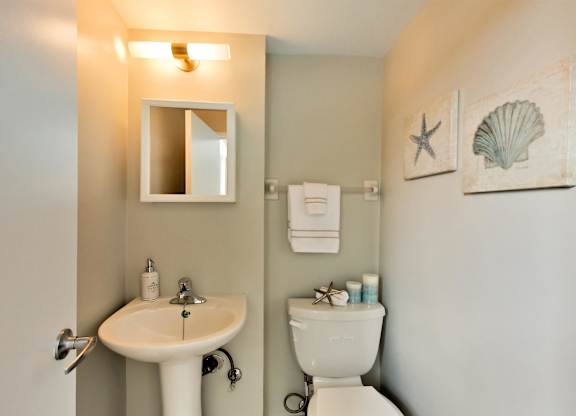 a bathroom with a toilet sink and a mirror