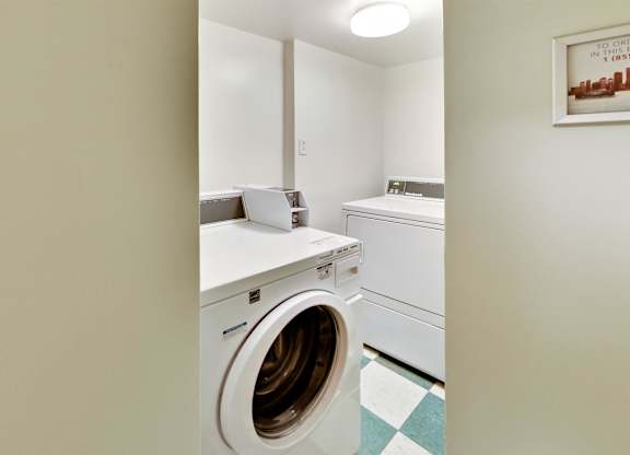 a washer and dryer in a laundry room with a sink and a mirror