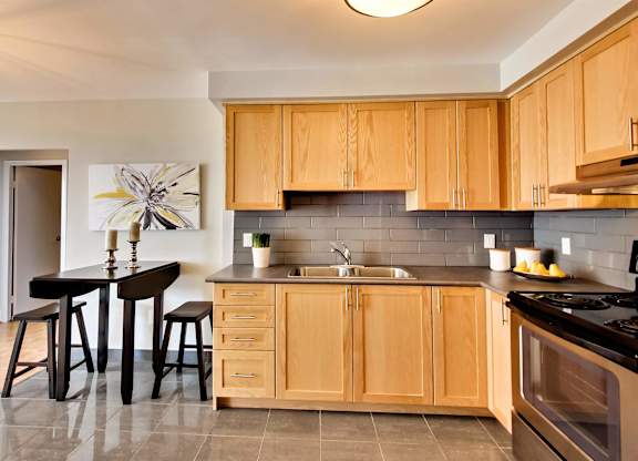 a kitchen with wooden cabinets and a table with stools