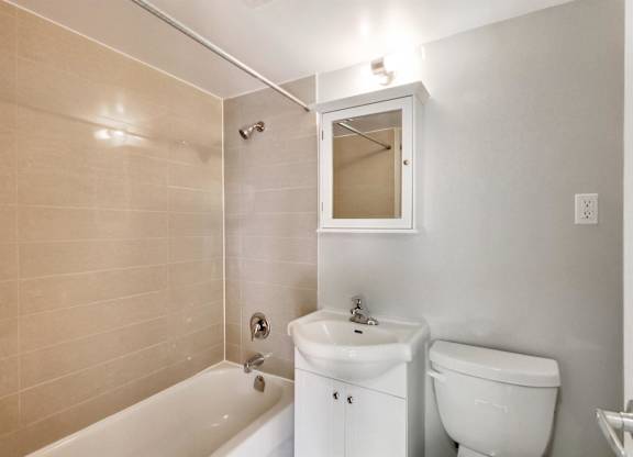 a bathroom with a toilet and a tub and a sink