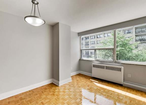 an empty living room with a large window and wood floors