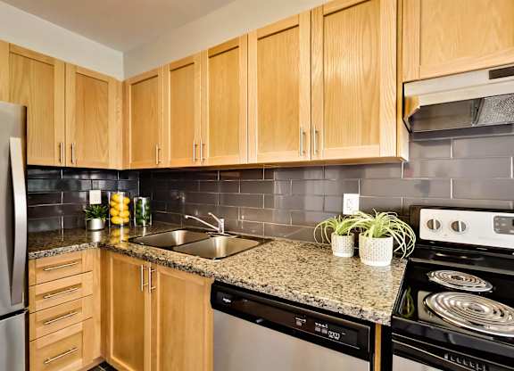 a kitchen with wooden cabinets and a granite counter top