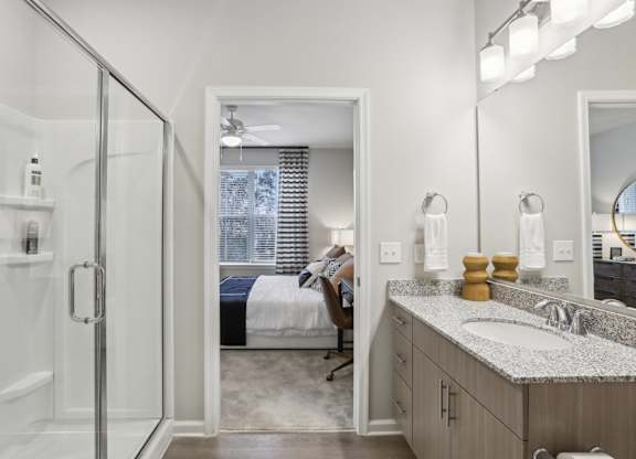 a bathroom with granite countertops and a walk-in shower