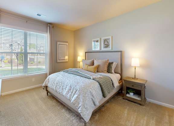 a large bedroom with a ceiling fan and window