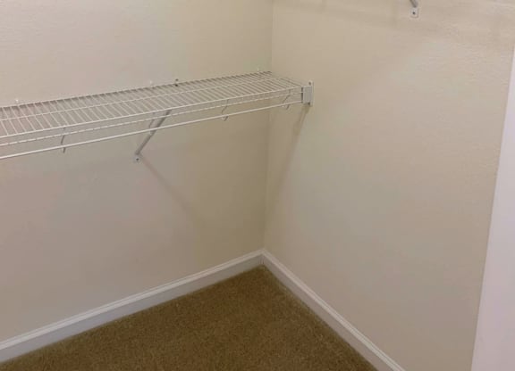 Empty white shelves in a corner of a room.