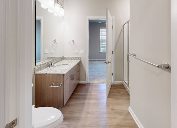 a bathroom with granite countertops a walk-in shower