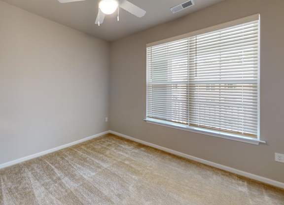 a bedroom with a ceiling fan and large window