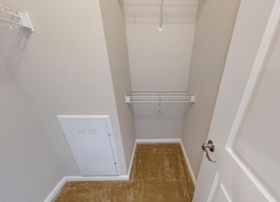 a walk-in closet with built in shelving