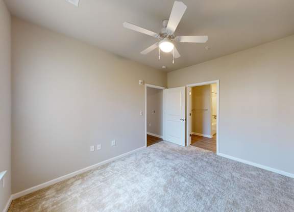 a bedroom with a connecting closet and bathroom