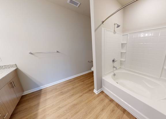 a bathroom with a tub and vinyl flooring