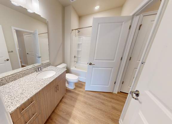 a bathroom with granite countertops and luxury vinyl flooring