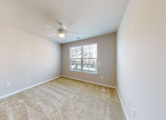 a bedroom with carpet and a ceiling fan