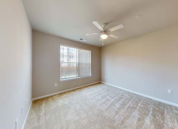 a bedroom with carpet and a ceiling fan