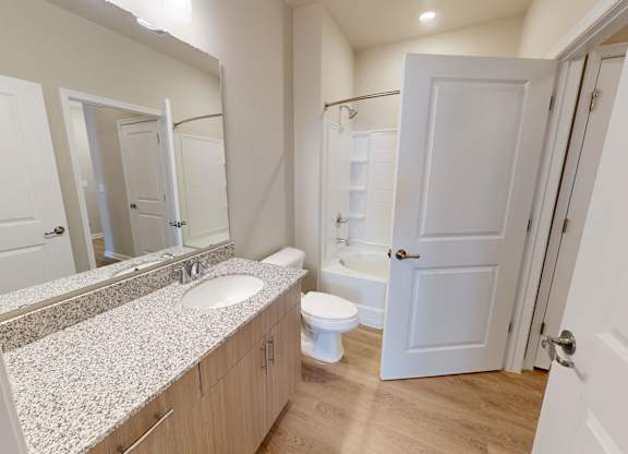 a bathroom with granite countertops and a tub